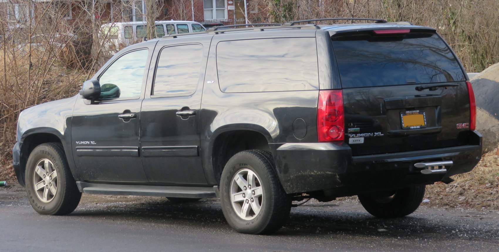 Black extended SUV with tinted windows and roof rails
