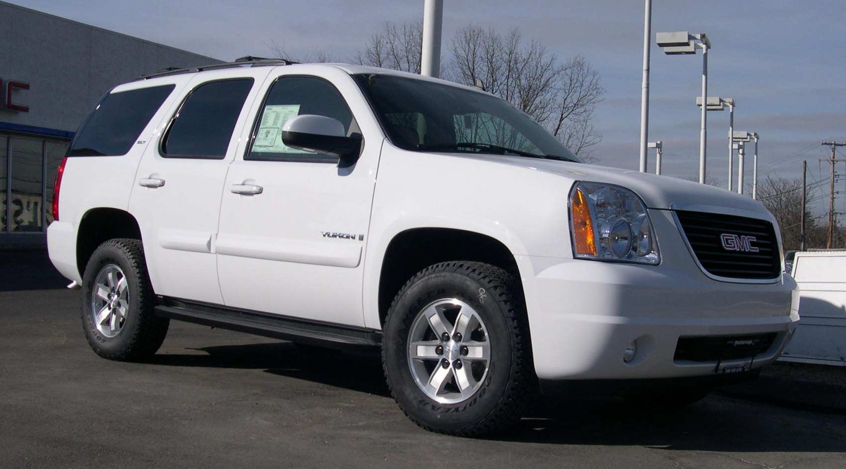 White full-size SUV front side view with rugged tires