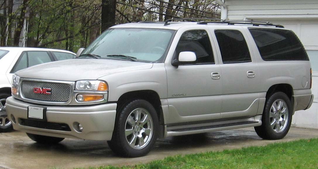 Silver extended-length SUV with chrome rims and roof rails