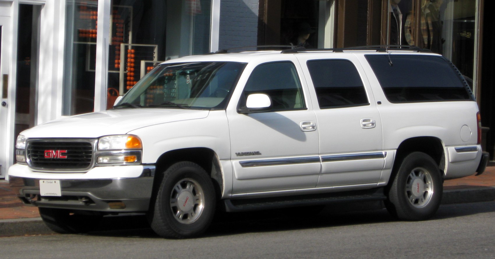 White extended SUV featuring tinted windows and side profile.