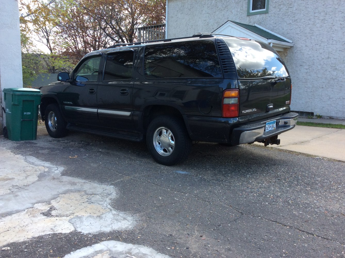 Rear side view of an extended SUV with chrome wheels and tinted windows