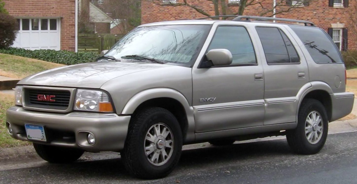 Front side profile of a silver midsize SUV with tinted windows and roof rack