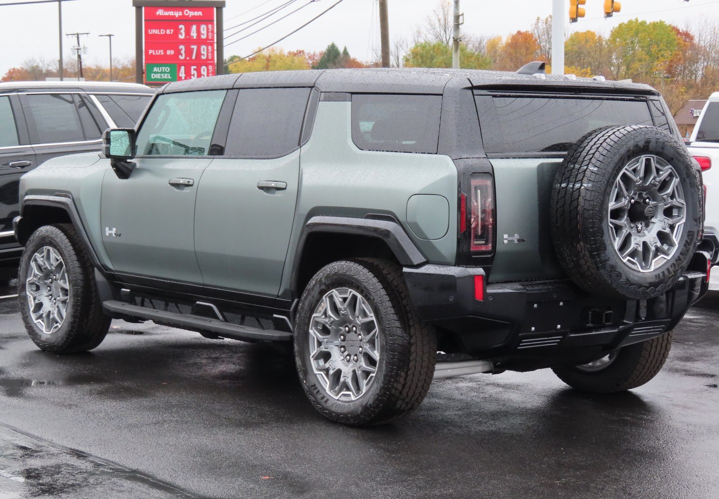 Rear side view of EV SUV with spare tire mount and rugged wheels