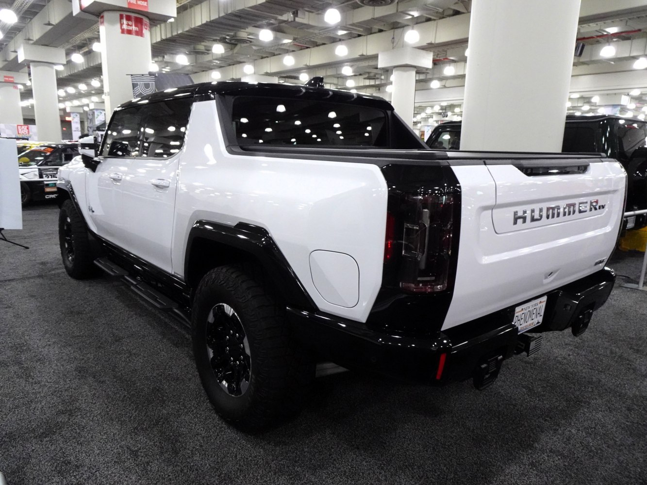 Rear view of white and black electric pickup with rugged styling and spacious bed