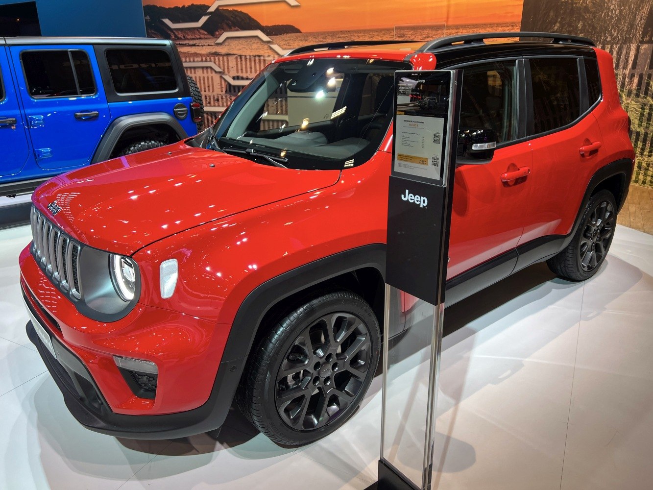 Red SUV with black wheels, round headlights, and seven-slot grille