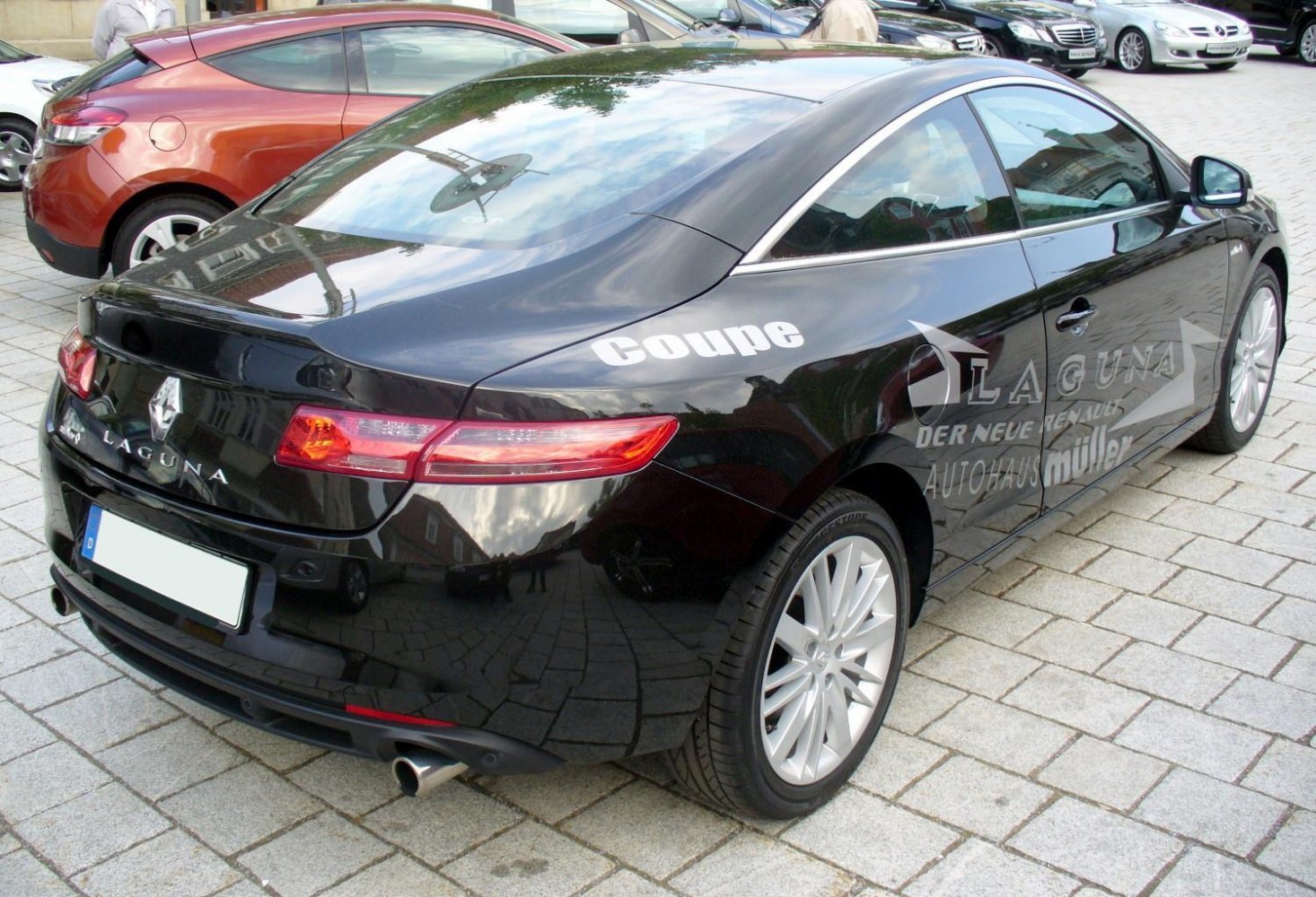 Rear view and side profile of a black coupe showing sleek taillights and alloy wheels.