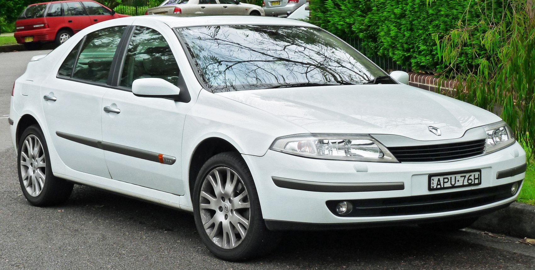 White sedan front side view with alloy wheels and distinct headlights