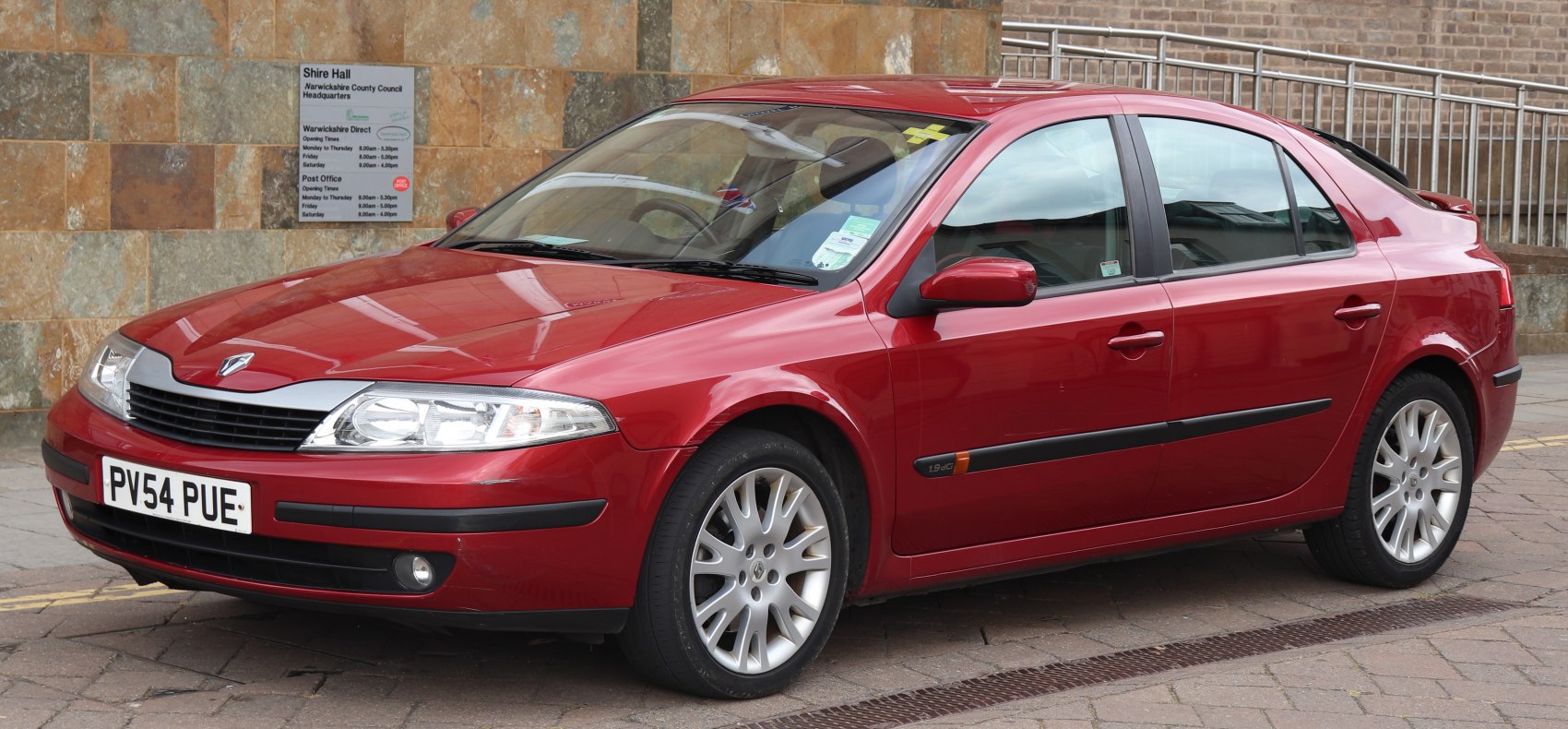 Red 4-door sedan with alloy wheels and side moldings