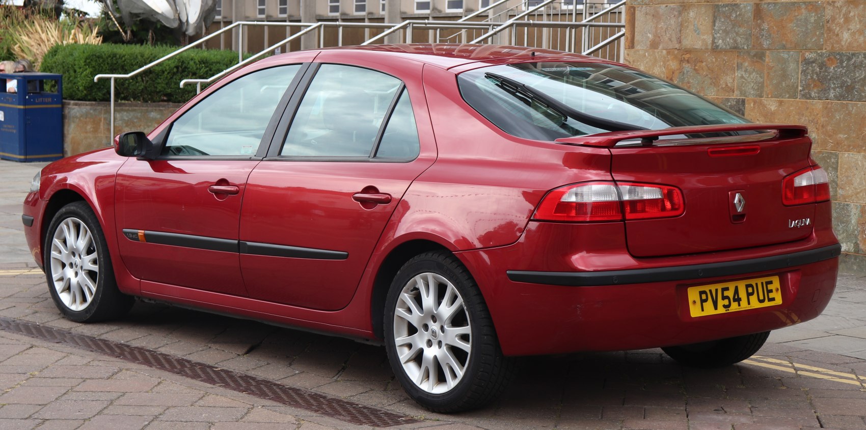 Red sedan rear side view with spoiler and alloy wheels