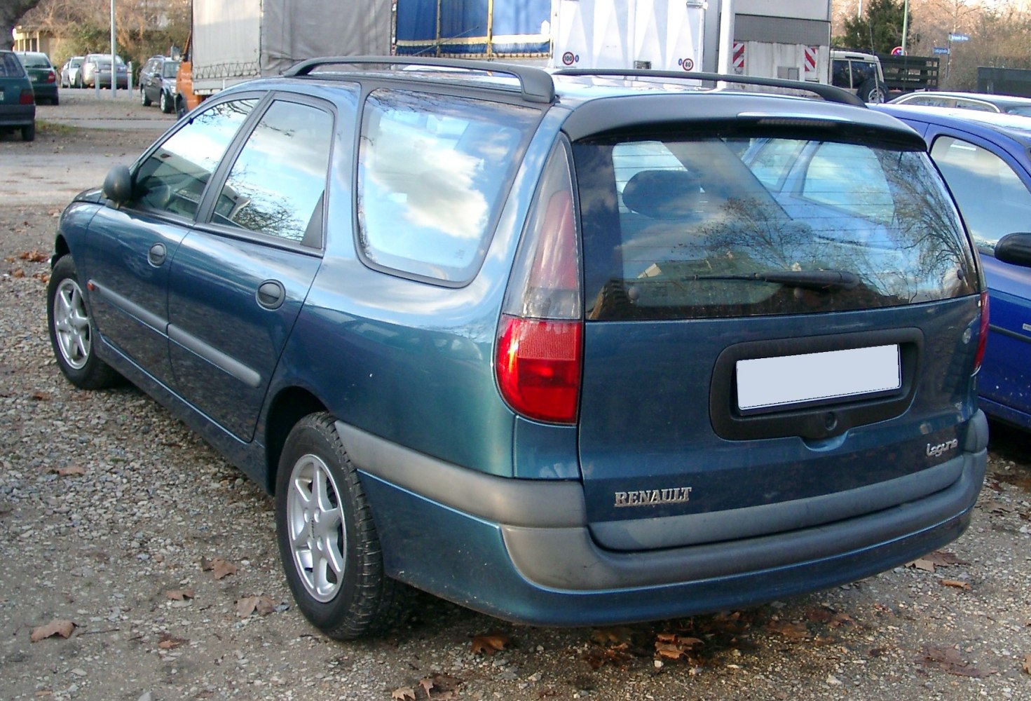 Rear side view of a 1990s station wagon with roof rails and distinctive taillights