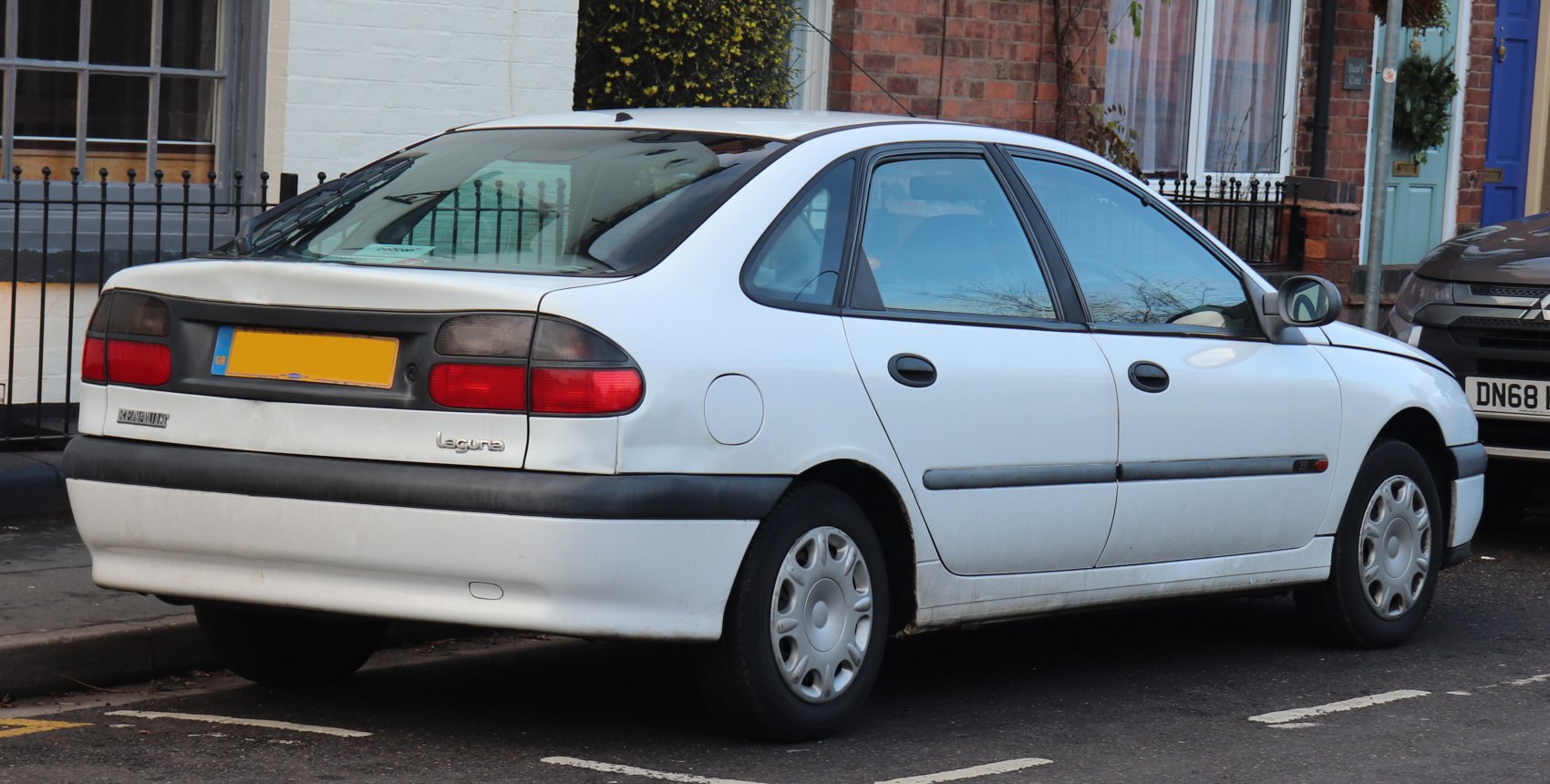 White sedan rear side with distinct taillight cluster and black trim