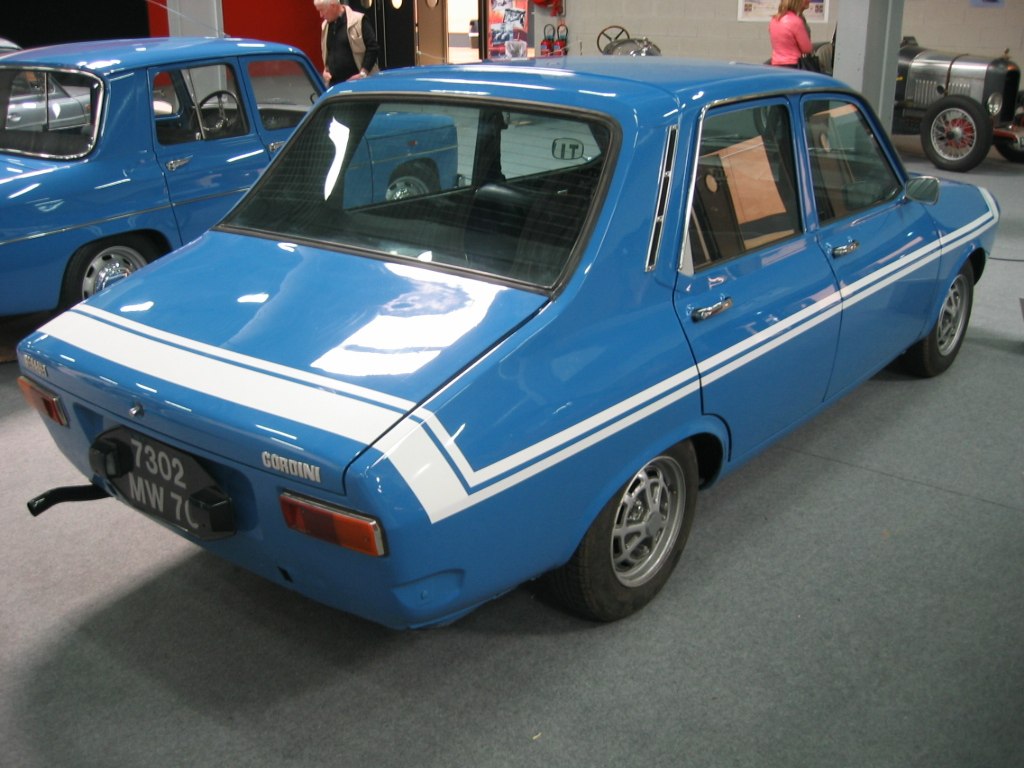 Blue vintage sedan with white racing stripes and retro rear design.