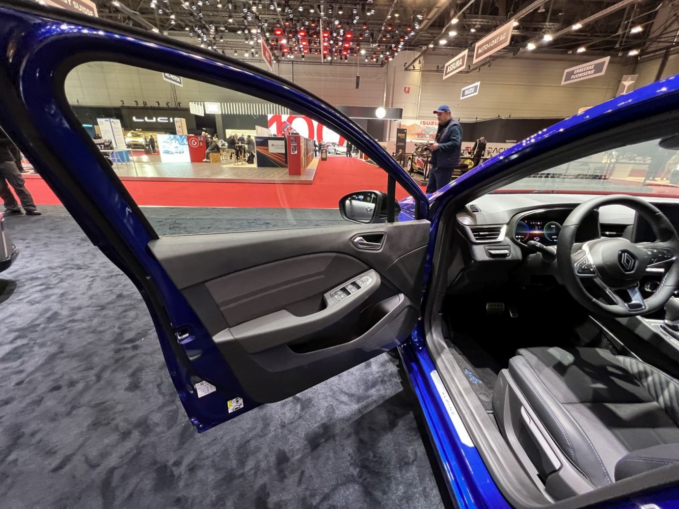 Interior door panel and digital dashboard with power window controls and steering wheel.