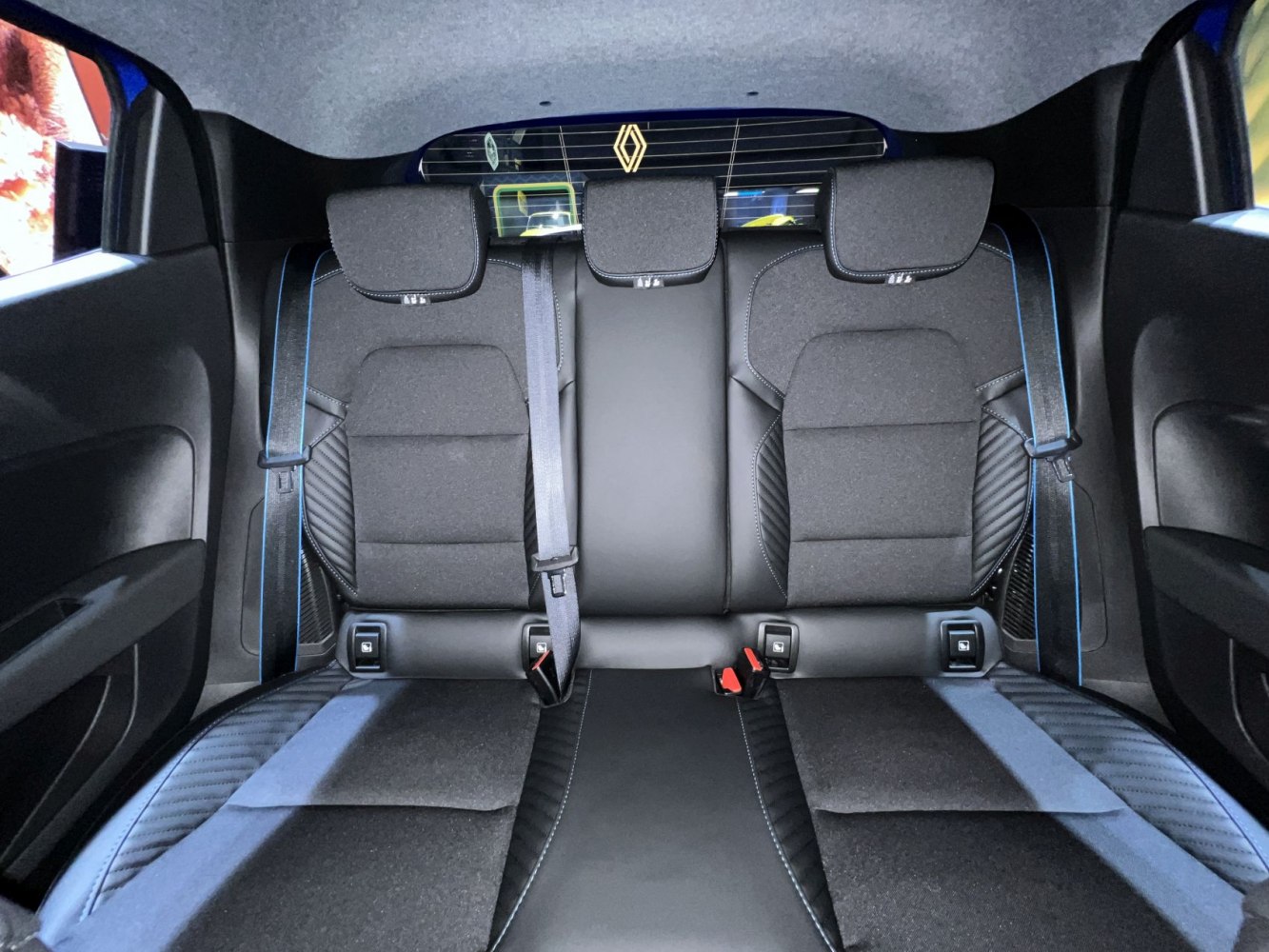 Rear seat interior with fabric and leather upholstery, three headrests, and seat belts