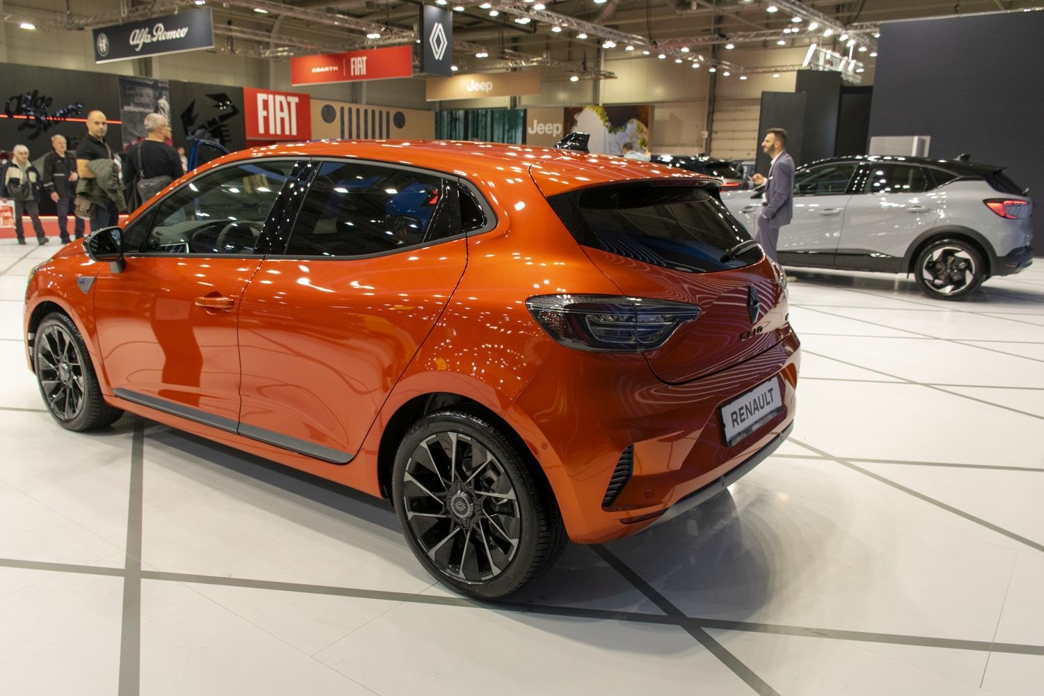 Orange hatchback rear-side view with sporty rims and sleek taillights