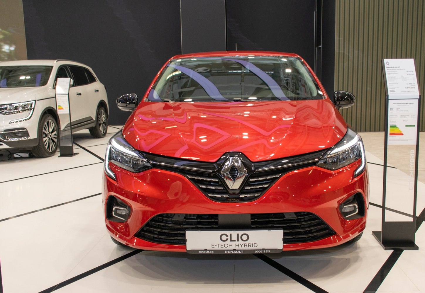 Front view of red compact hatchback with hybrid badge