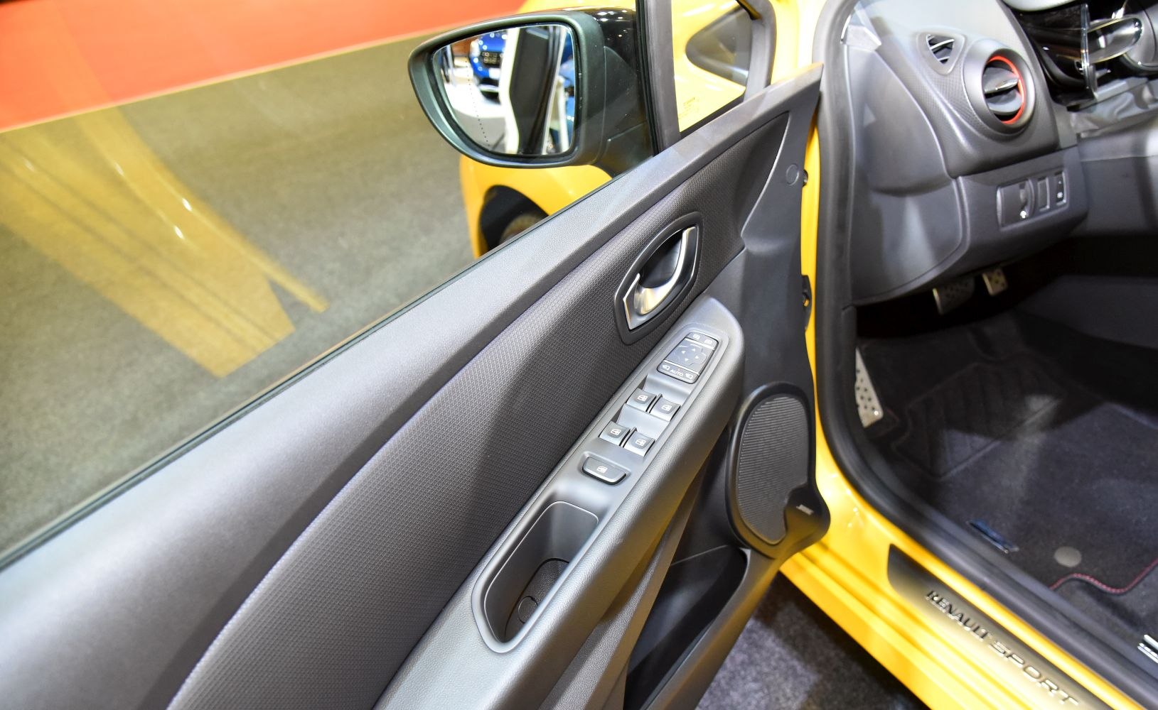 Interior door panel with window controls, speaker, and door handle