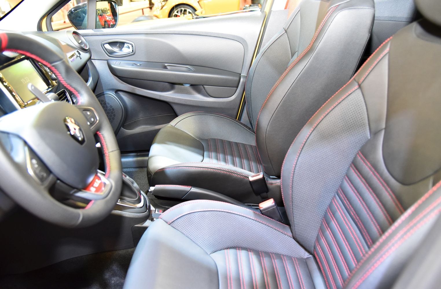 Front interior seats and steering wheel with red stitching and textured upholstery
