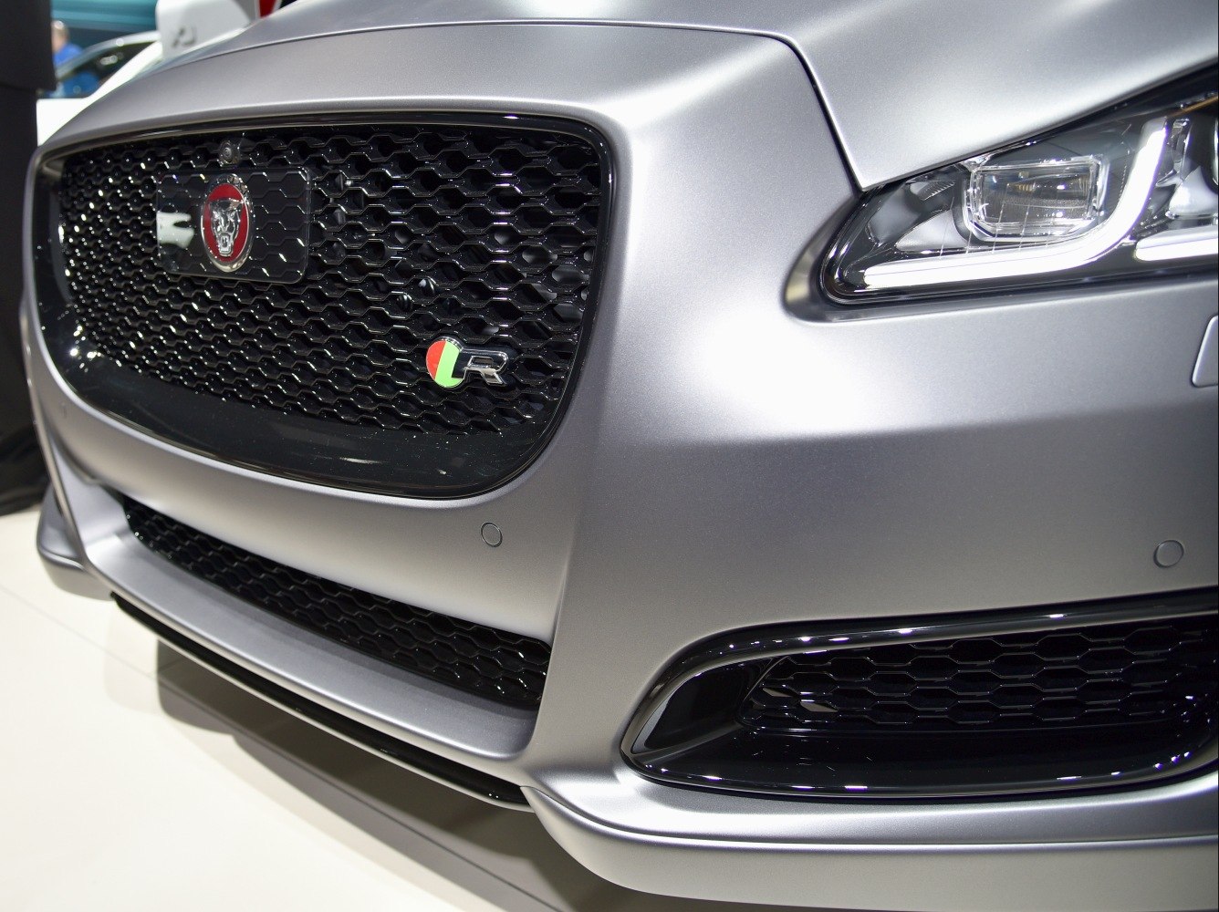 Close-up of front grille with R badge and sleek headlight