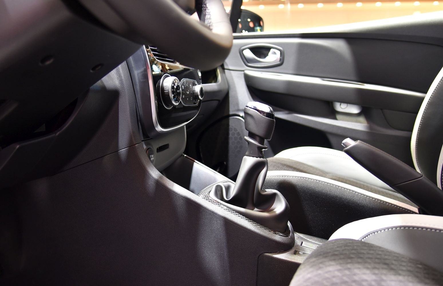 Manual gear stick and dashboard controls inside car interior