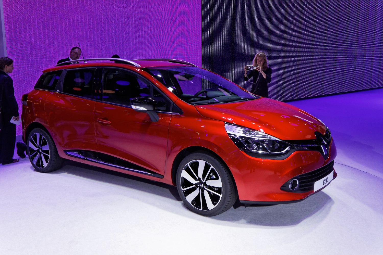 Front-side view of red station wagon with alloy wheels and modern headlights