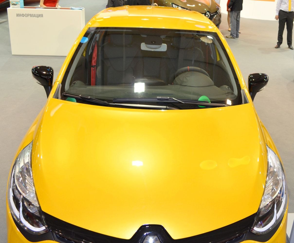 Yellow compact car front with prominent headlights and windshield