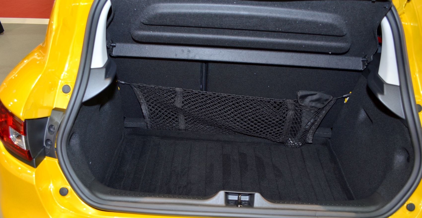 Open rear cargo trunk with black interior and net organizer.