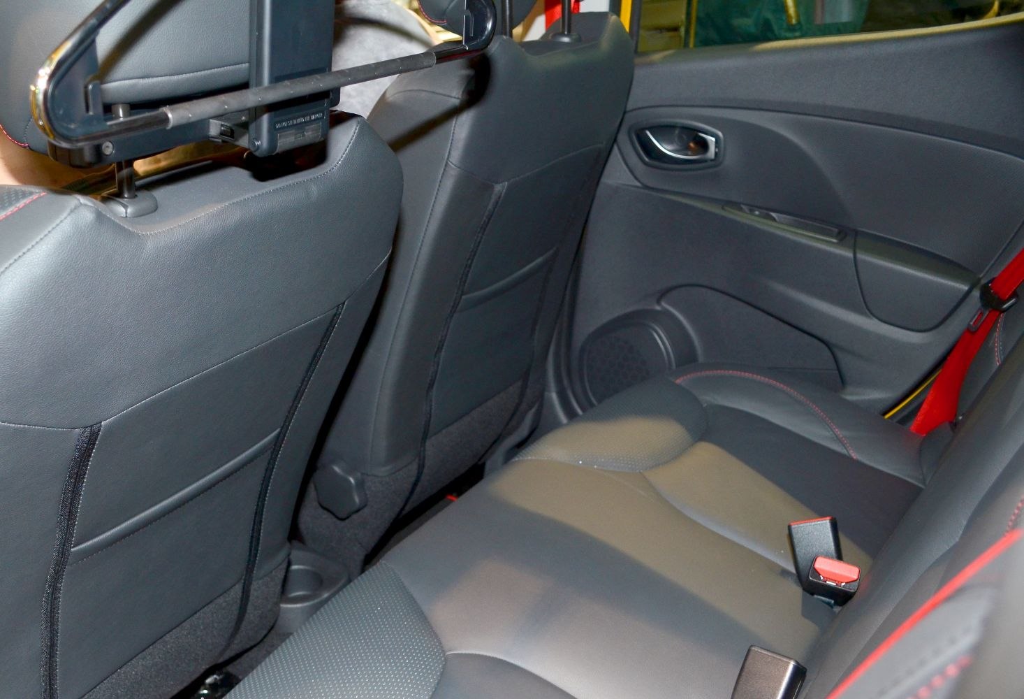 Rear seat with black leather upholstery and red contrast stitching