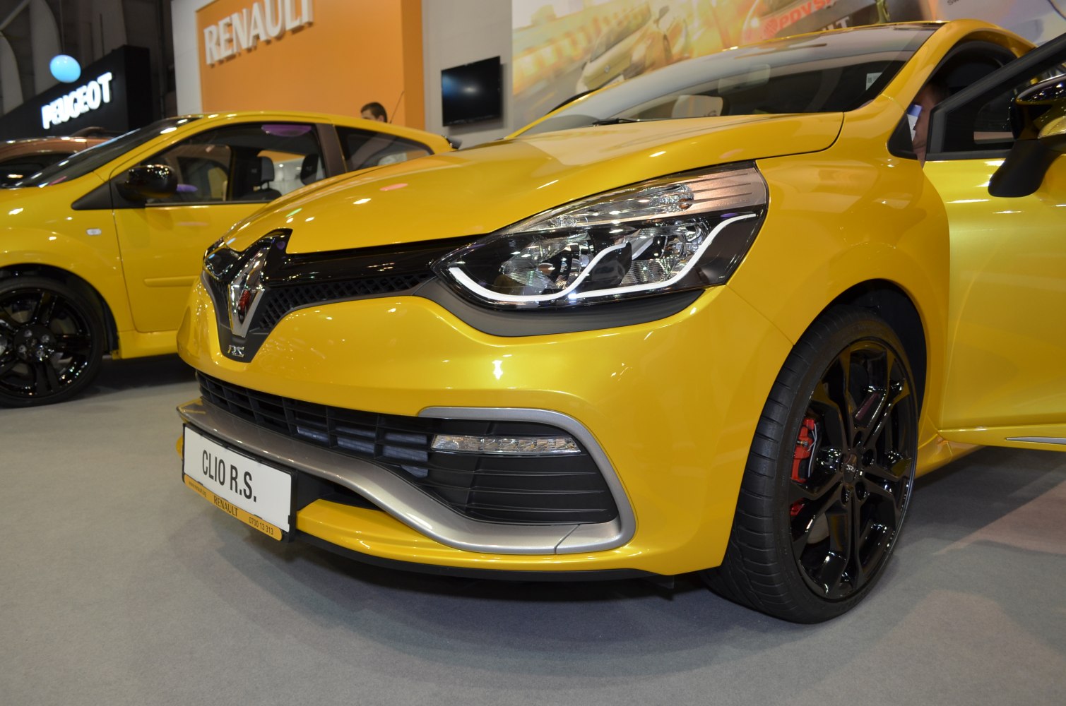 Close-up of car front with headlights and sporty black alloy wheels
