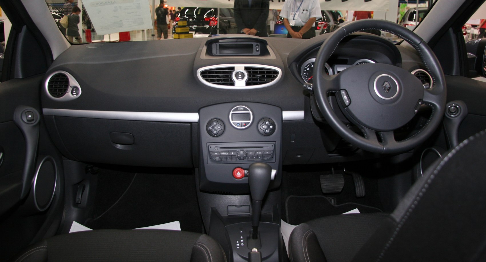 Right-hand drive dashboard and steering wheel with automatic gear shifter.