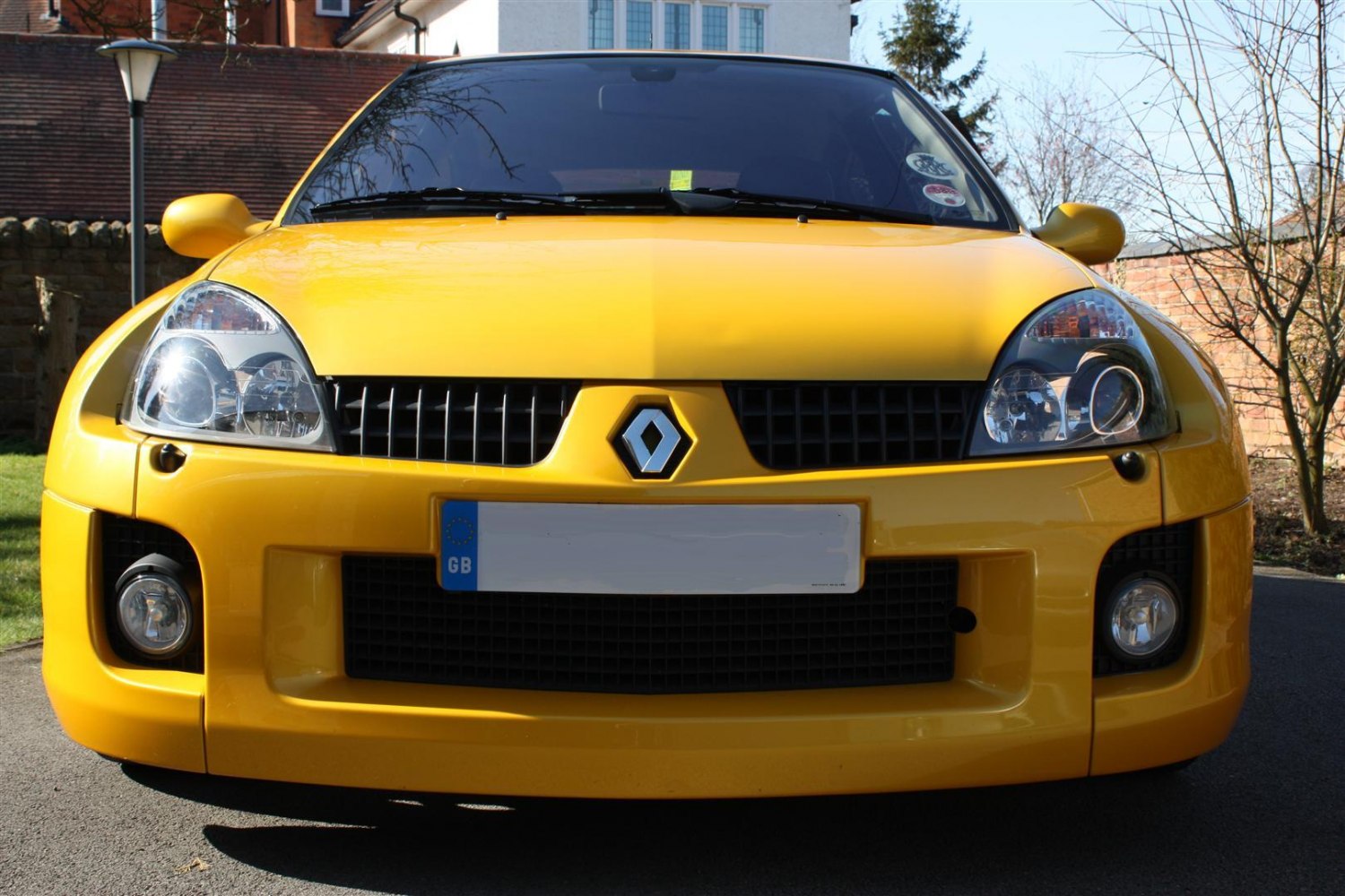 Front view of yellow hatchback with headlights and grille