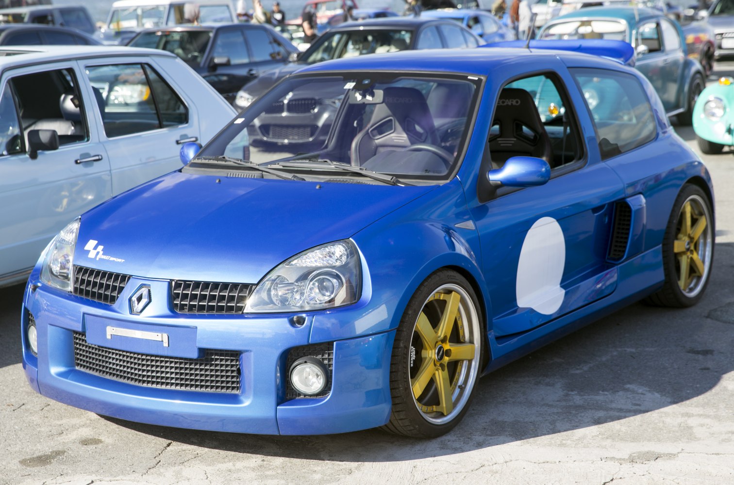 Blue hatchback with gold alloy wheels and racing-style body features