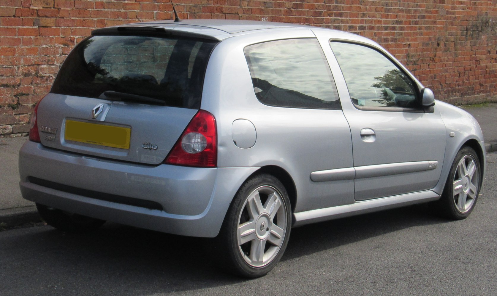 Rear-side view of a compact 3-door hatchback with alloy wheels and rear spoiler
