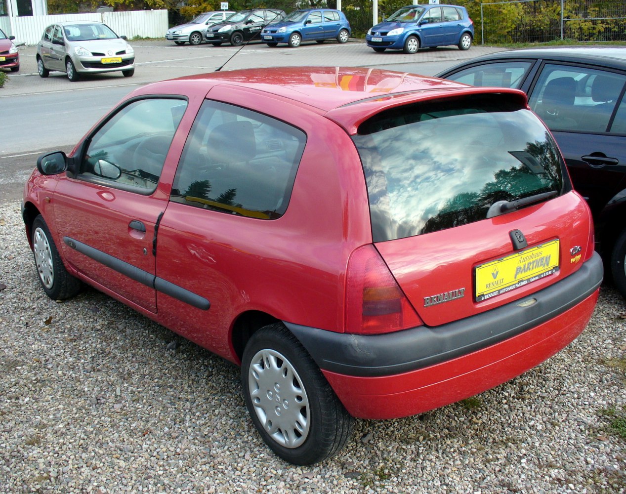 Rear side of compact 3-door hatchback with roof spoiler and rounded rear