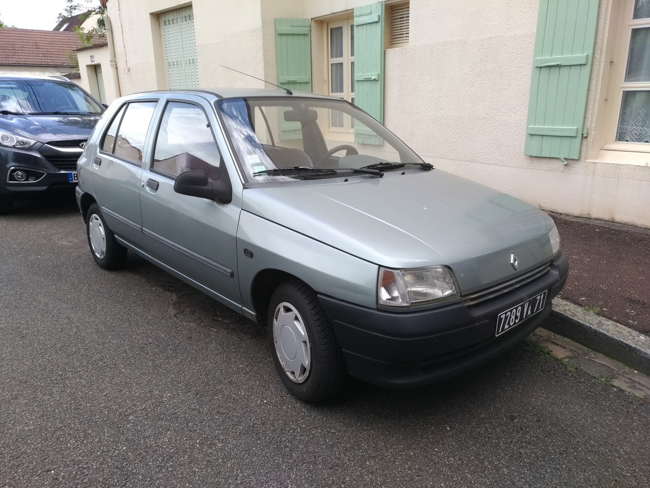 Compact 1990s four-door hatchback with simple design.