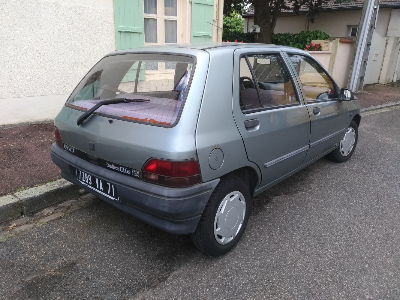 Rear side view of a compact 1990s hatchback with simple rear lights and angled rear window