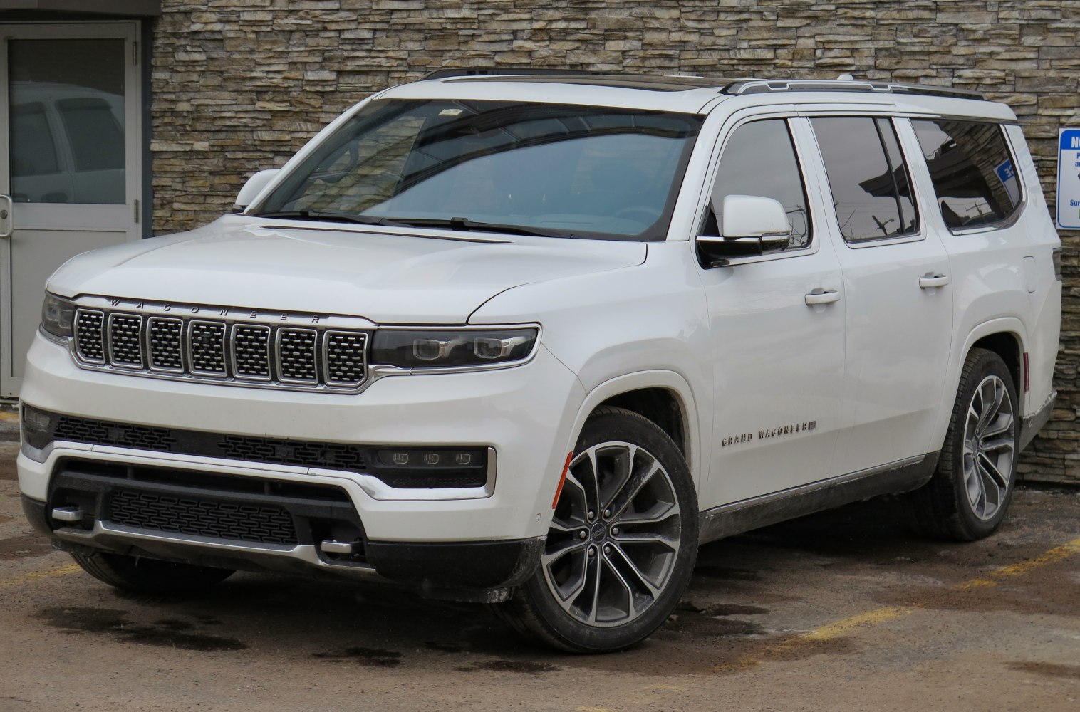 White large SUV with modern LED headlights and front grille