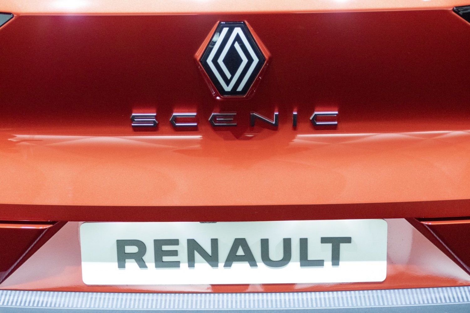 Close-up of car rear badge and logo on orange surface