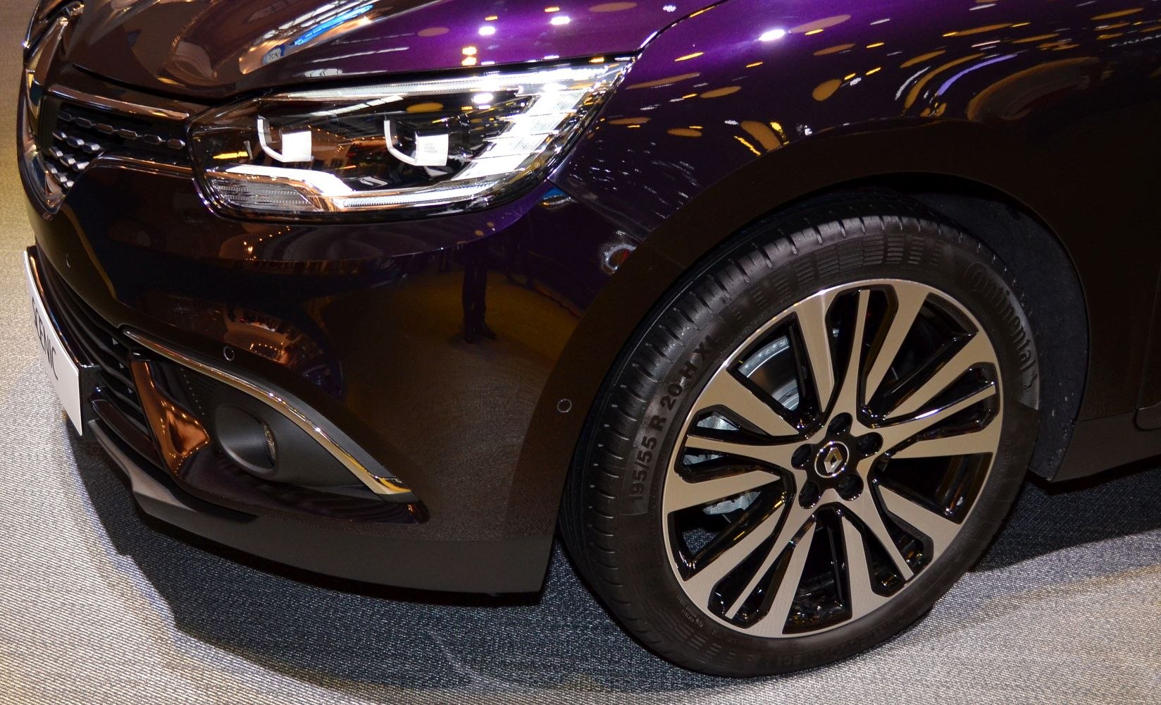 Close-up of modern headlight and stylish alloy wheel with intricate design