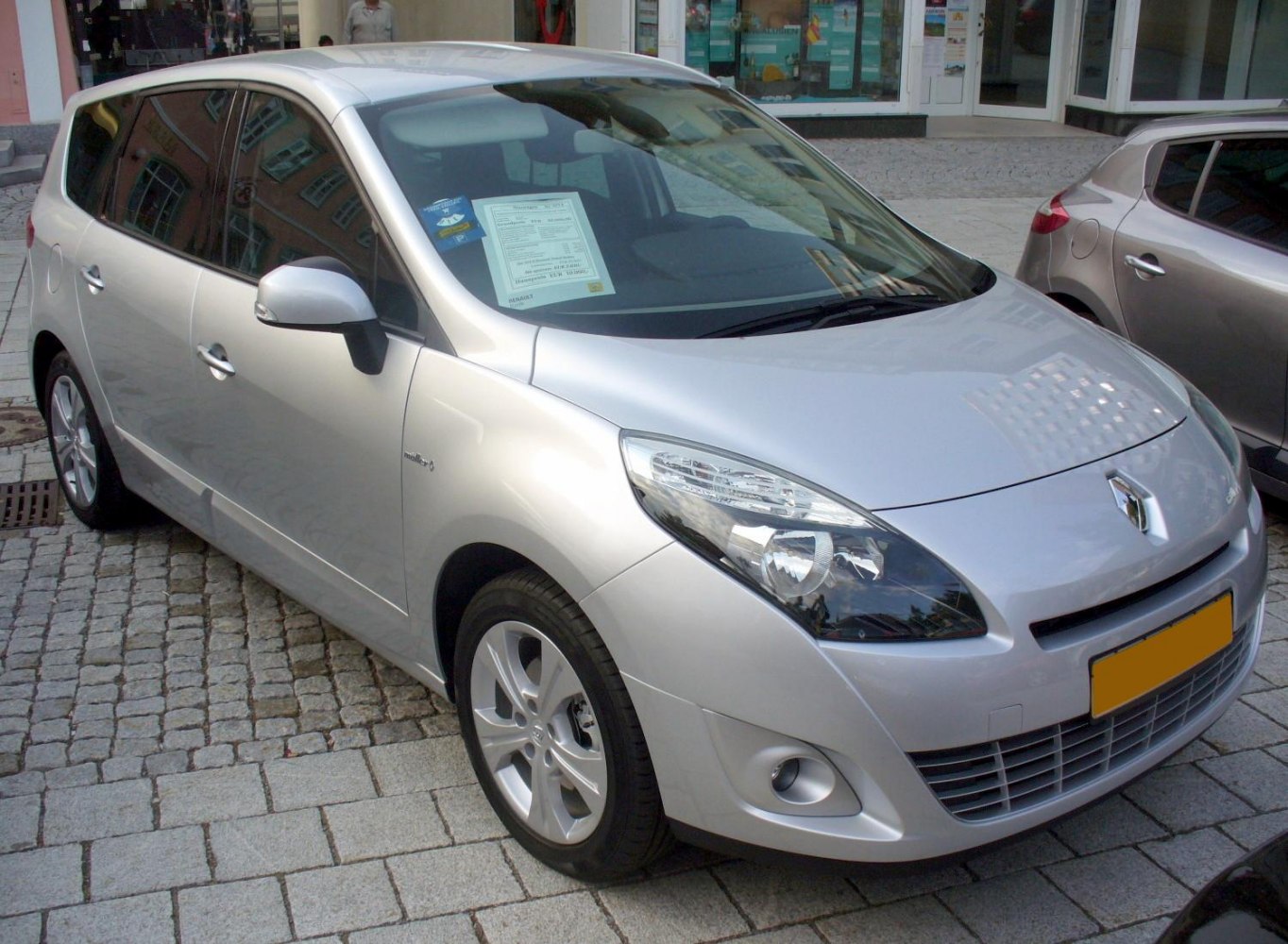 Silver MPV front-side view with sleek headlights and alloy wheels