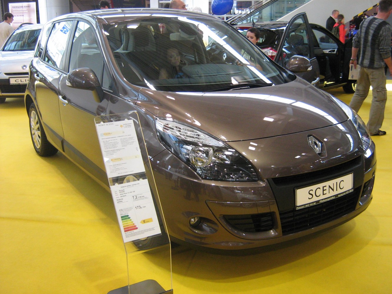 Front view with headlight and grille of a compact MPV on yellow floor