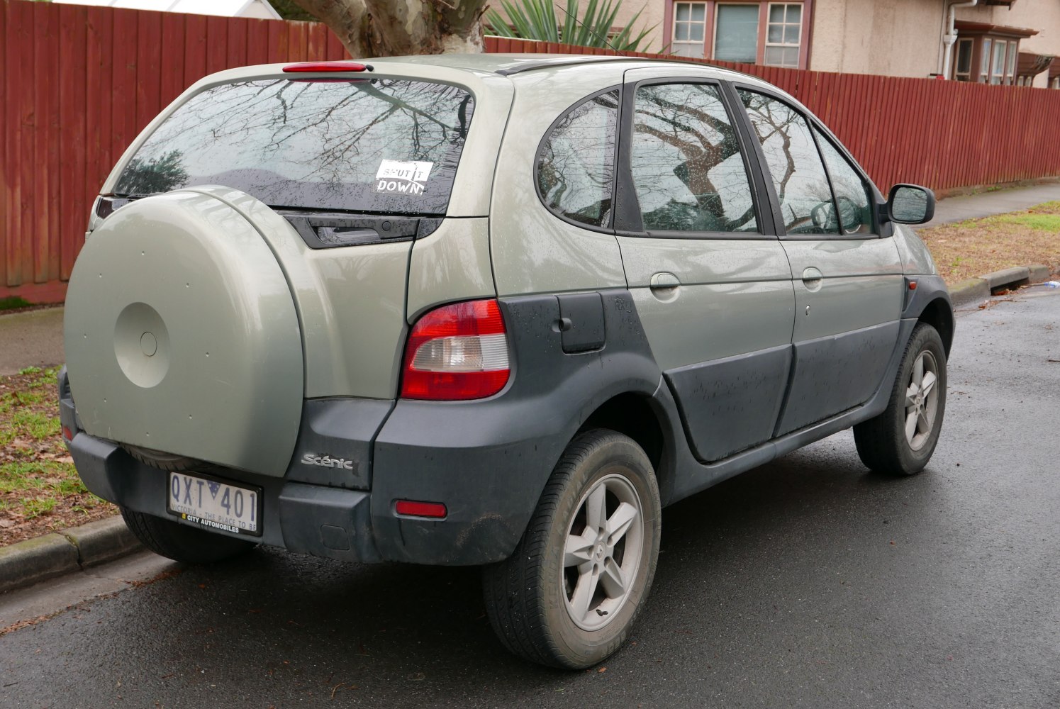 Rear side view with spare wheel cover and unique rear design.