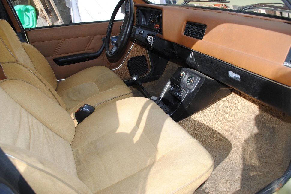 Classic vintage car interior with beige seats and manual gear shift
