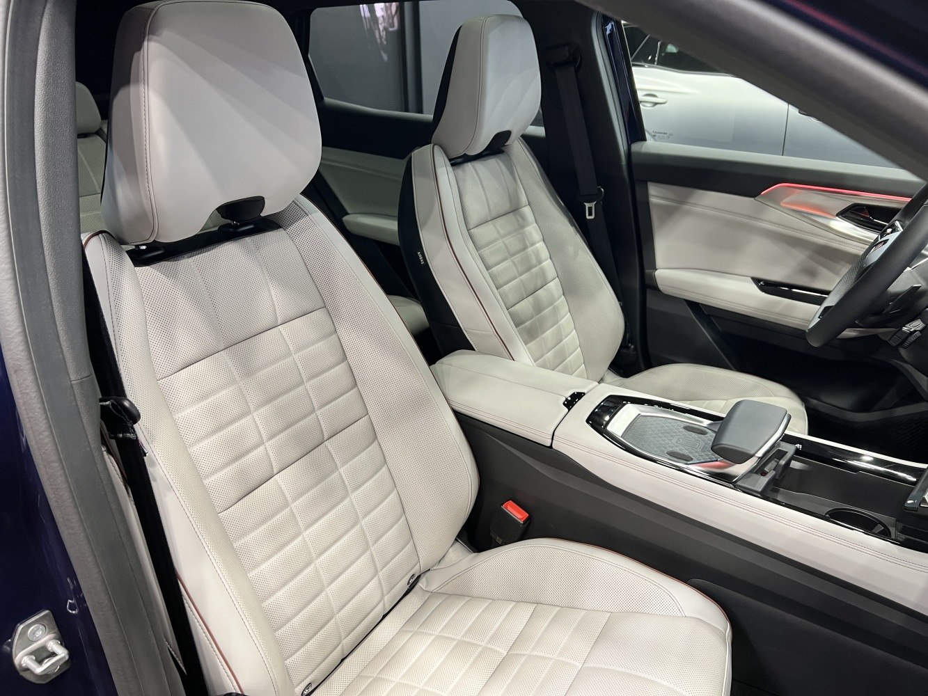 Luxurious white leather front seats and modern center console interior