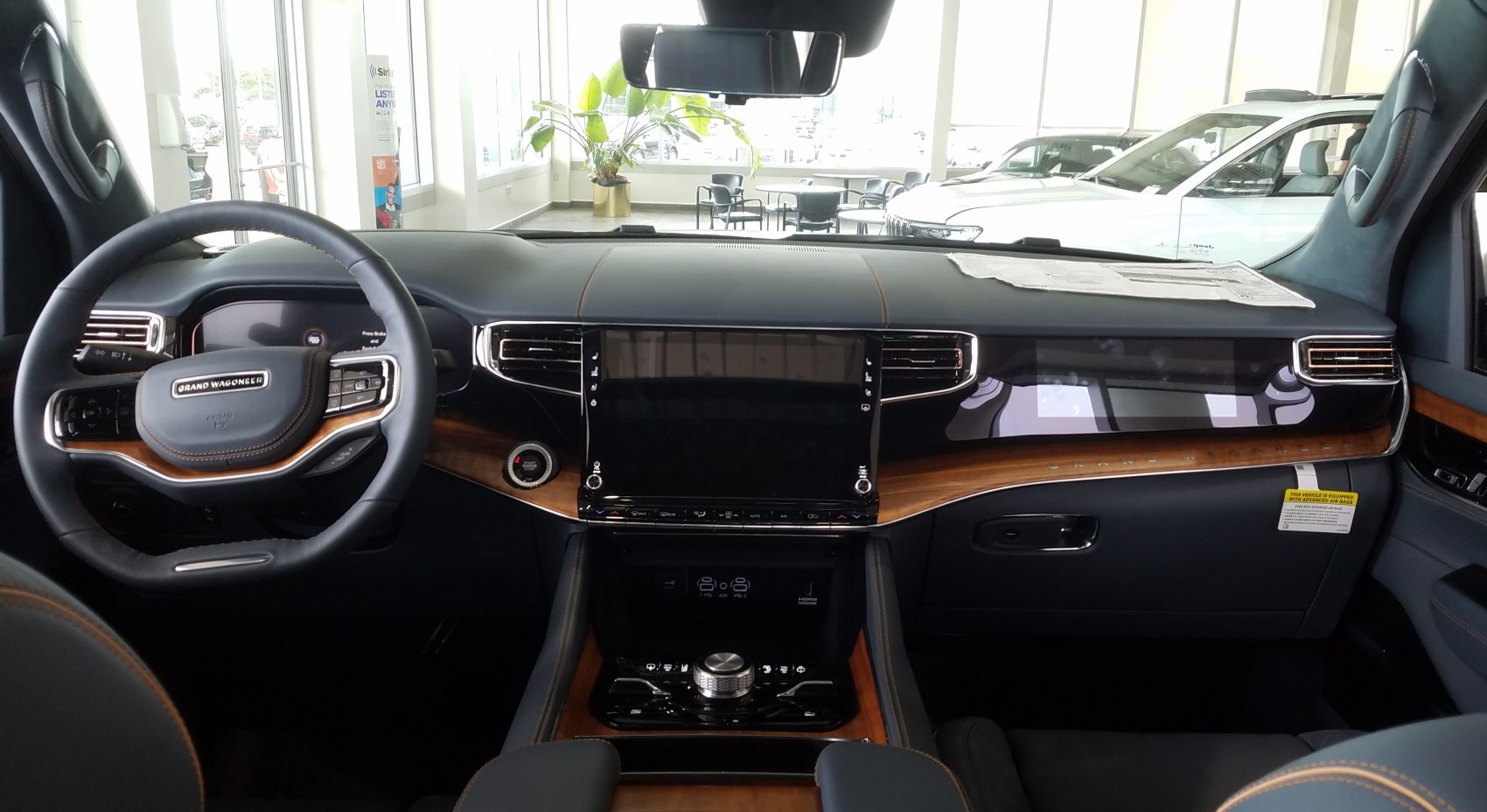 Luxury car interior with dashboard and steering wheel featuring wood trim and touchscreen