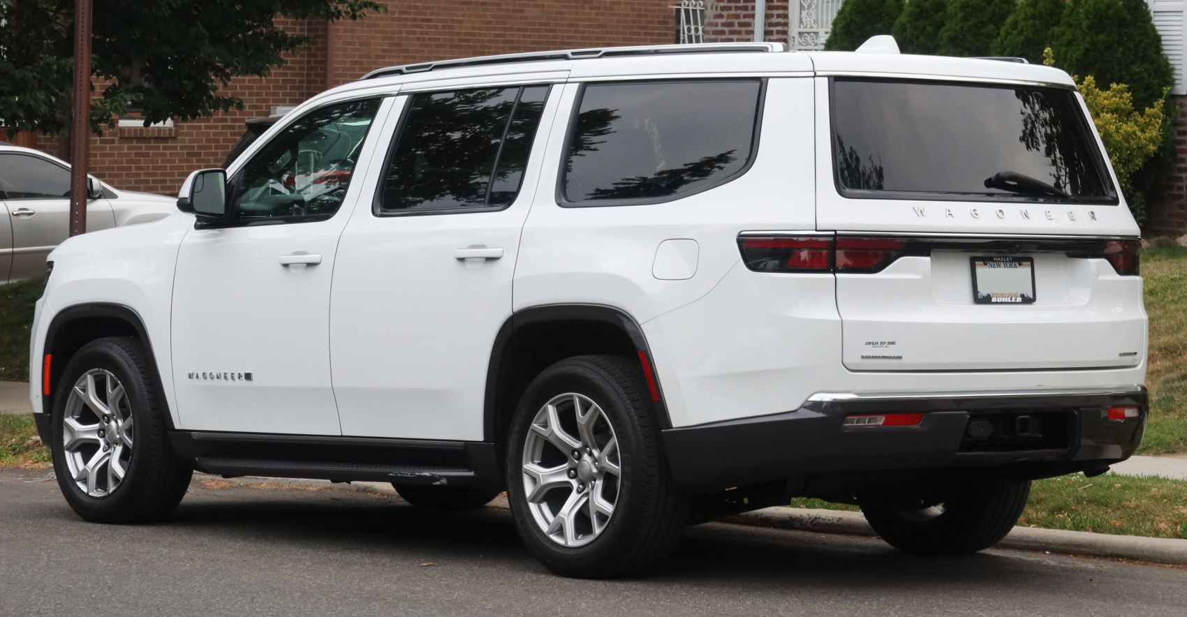 White large SUV side and rear view with distinctive taillight design and chrome wheels