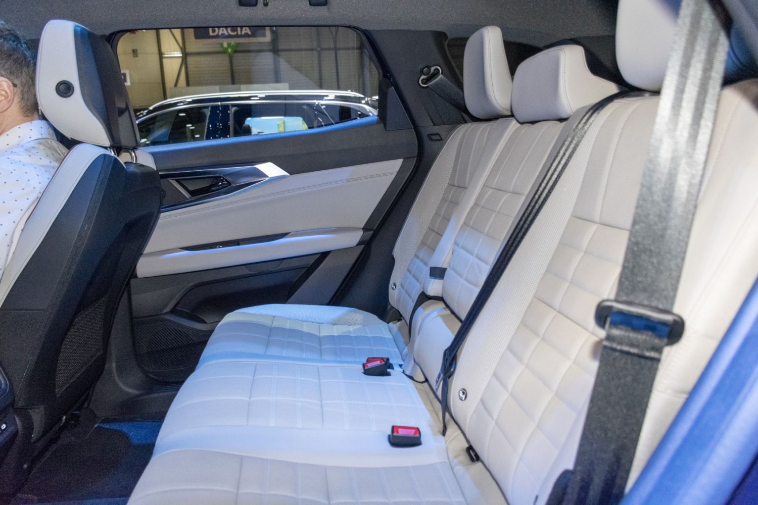 Spacious white leather rear seats with seat belts and door panel