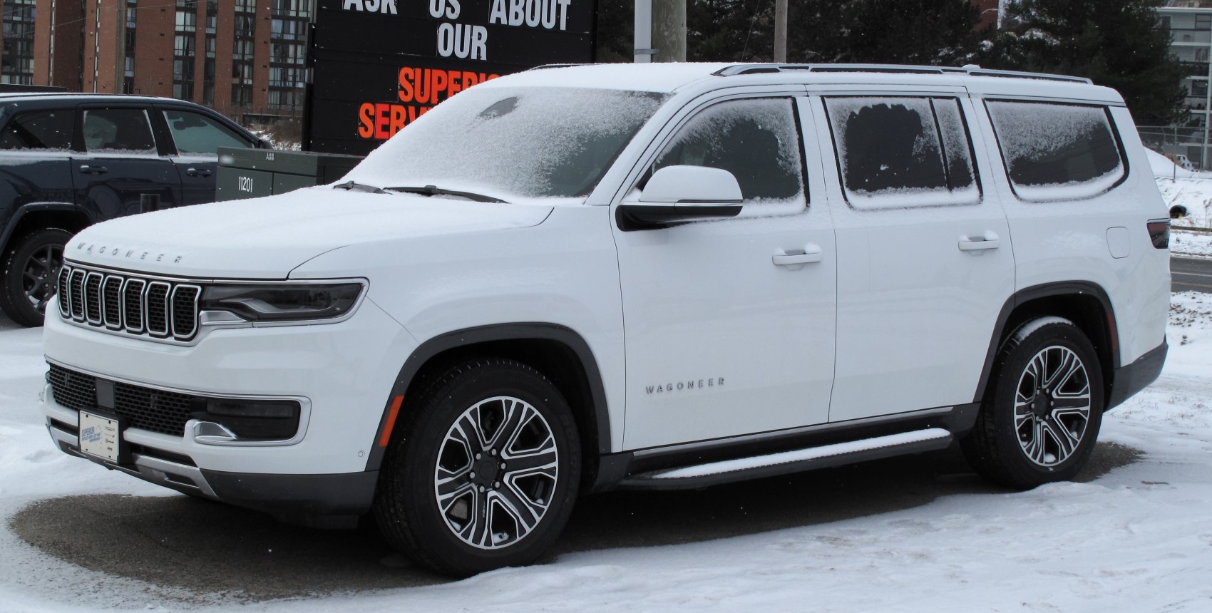 White SUV with snow covering, modern grille and alloy wheels