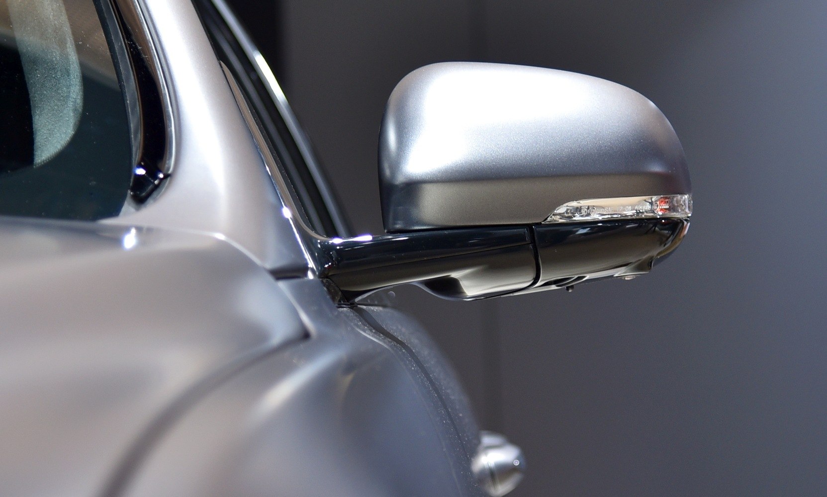 Close-up of side mirror with integrated indicator on luxury sedan