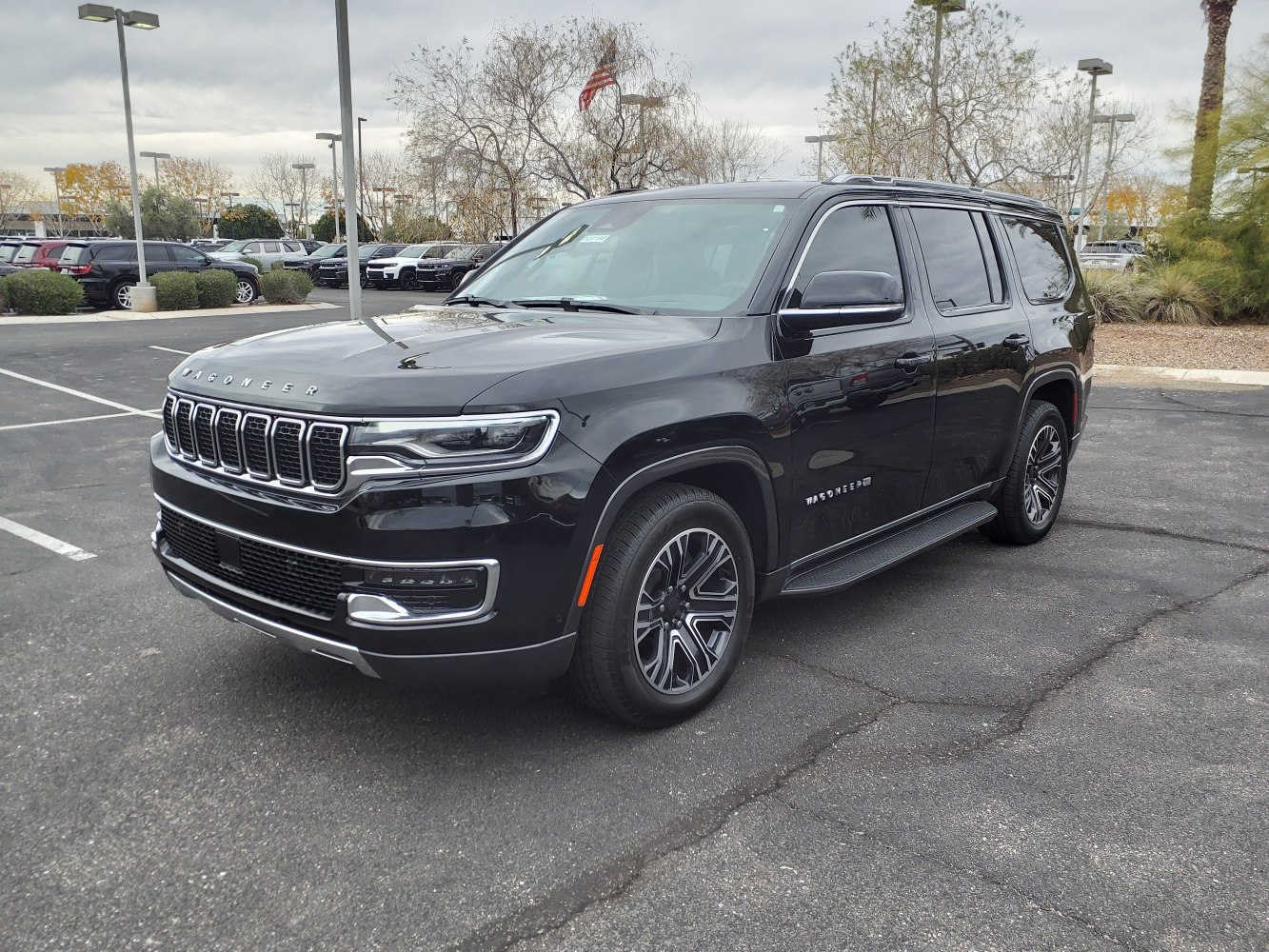 Black full-size SUV front side view with vertical grille and LED headlights
